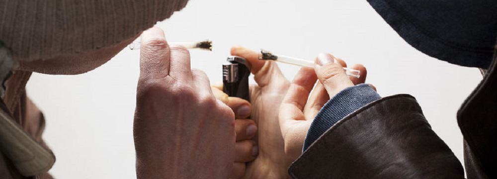 24492872 - close up of two man holding joints and lighter
