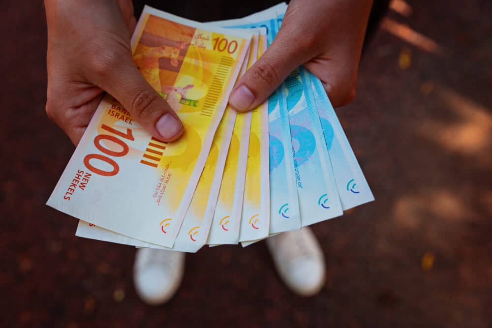 Woman's,Two,Hands,Holding,A,Fan,Of,Money,Of,Israeli עבירות מס